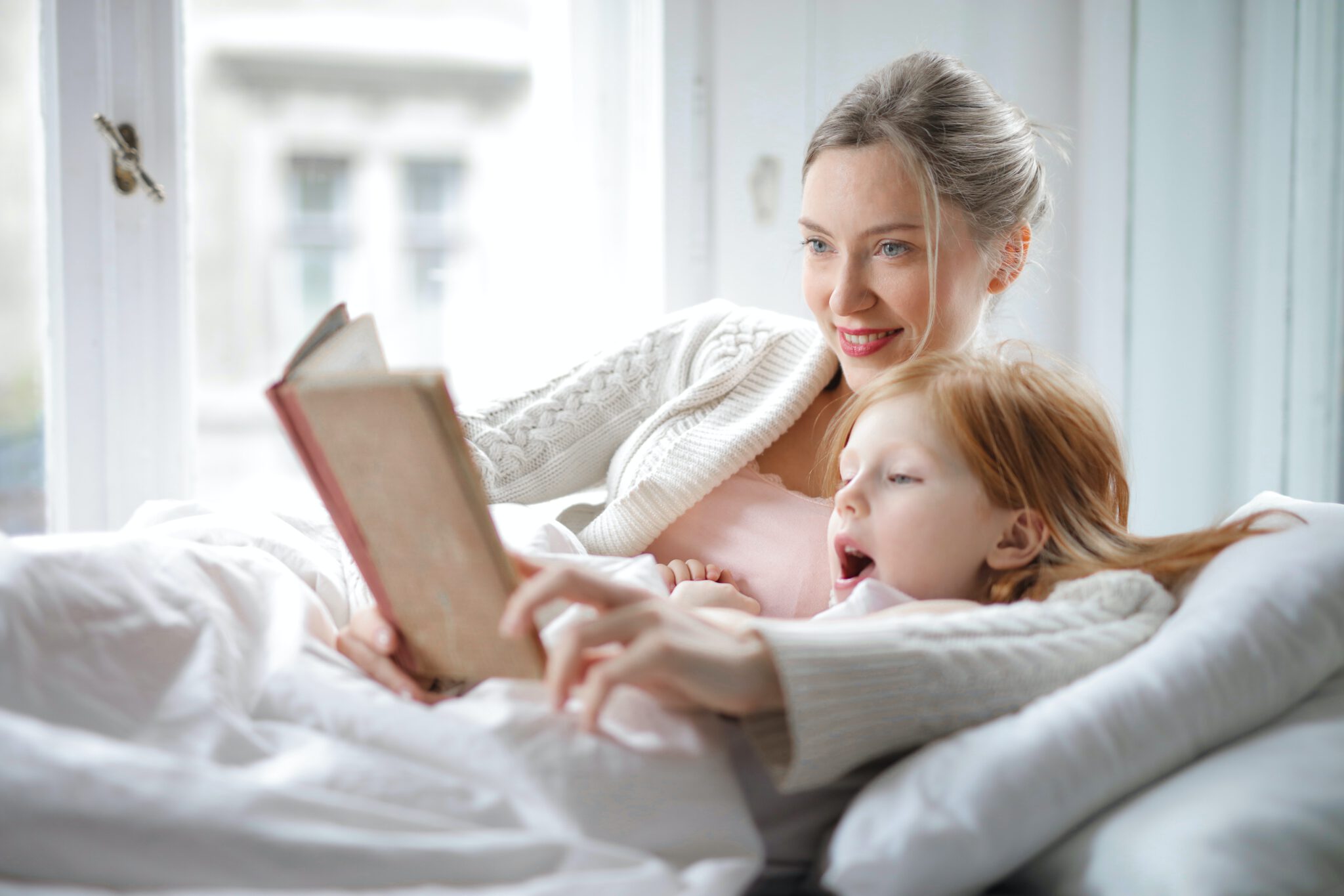 Moeder is een boek aan het voorlezen aan haar zoon in bed