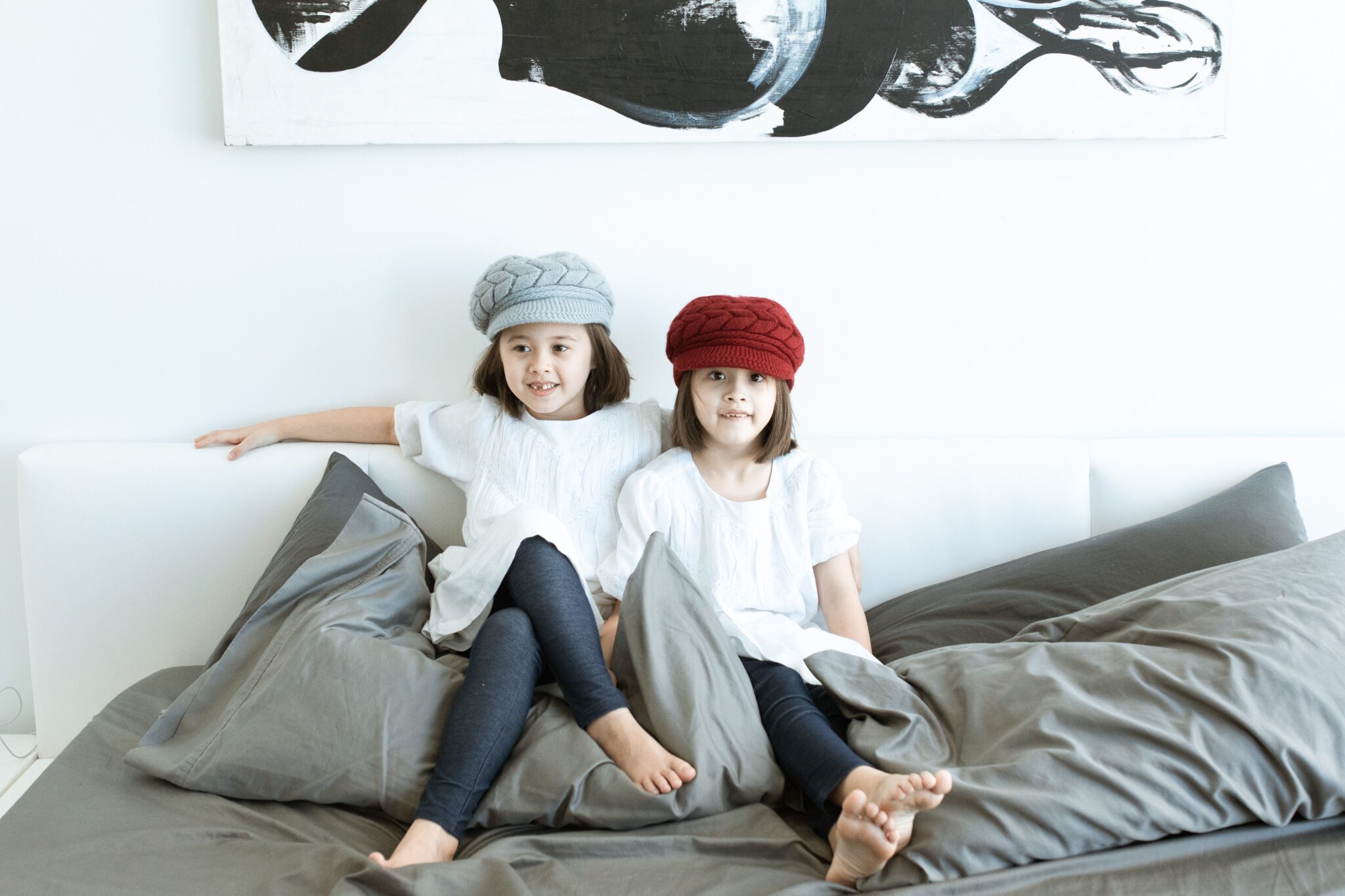 Twee kinderen zitten op bed- deze positie kunnen kinderen beter niet aannamen