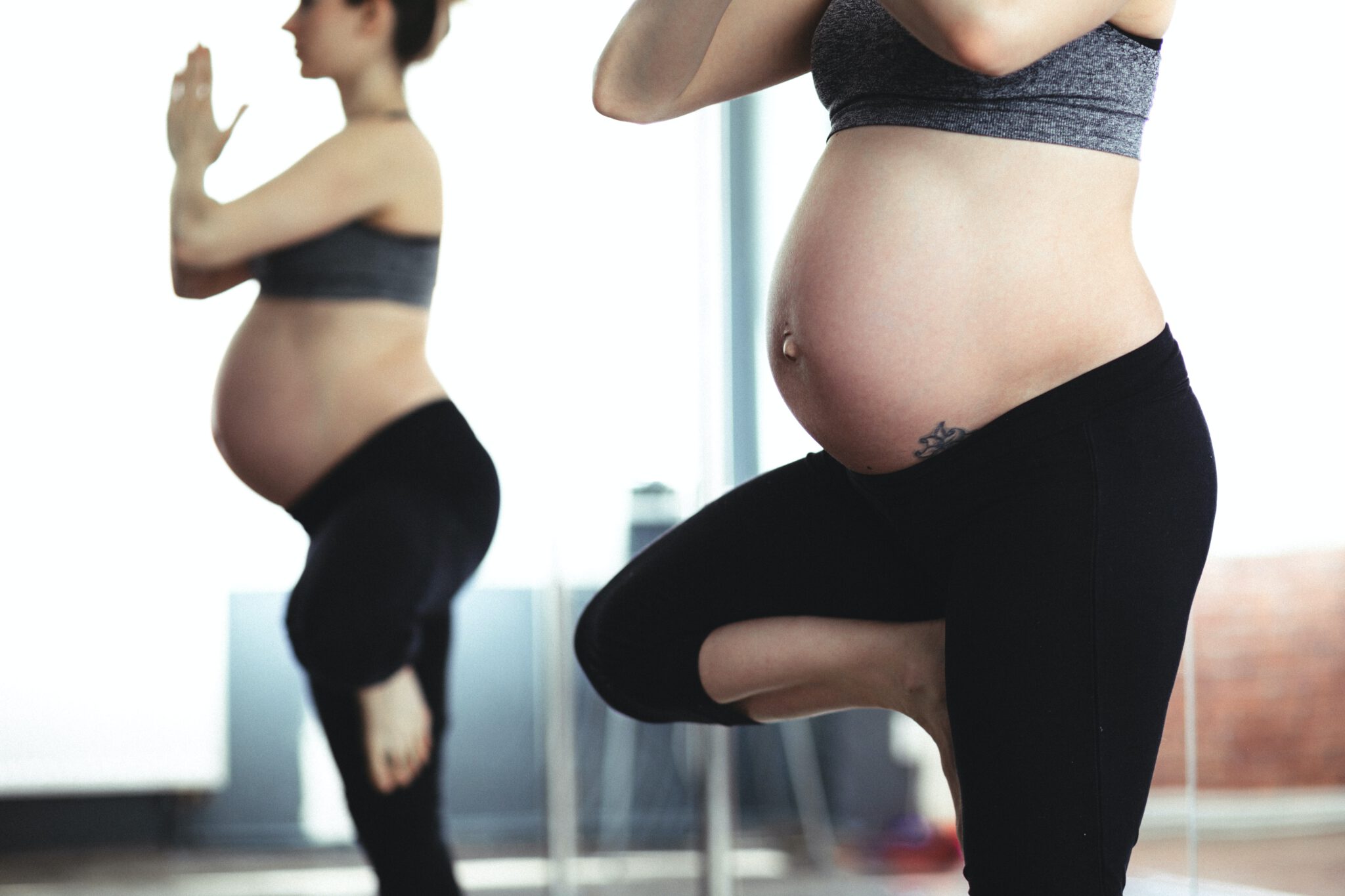 vrouw doet yoga pose en is nu zwanger