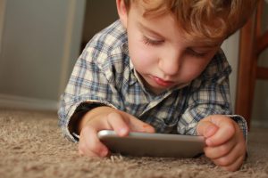 kind zit gehoorzaam op telefoon te spelen op basis van het montessori stappenplan