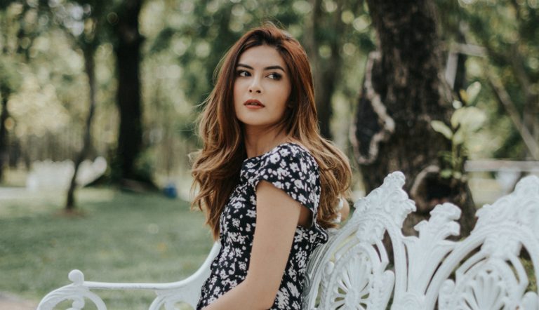 ex tegenkomen / vrouw zit op een bankje in het park