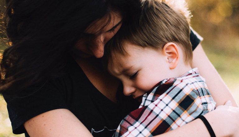 Moeder die haar zoon troost nadat ze net heel boos is geworden