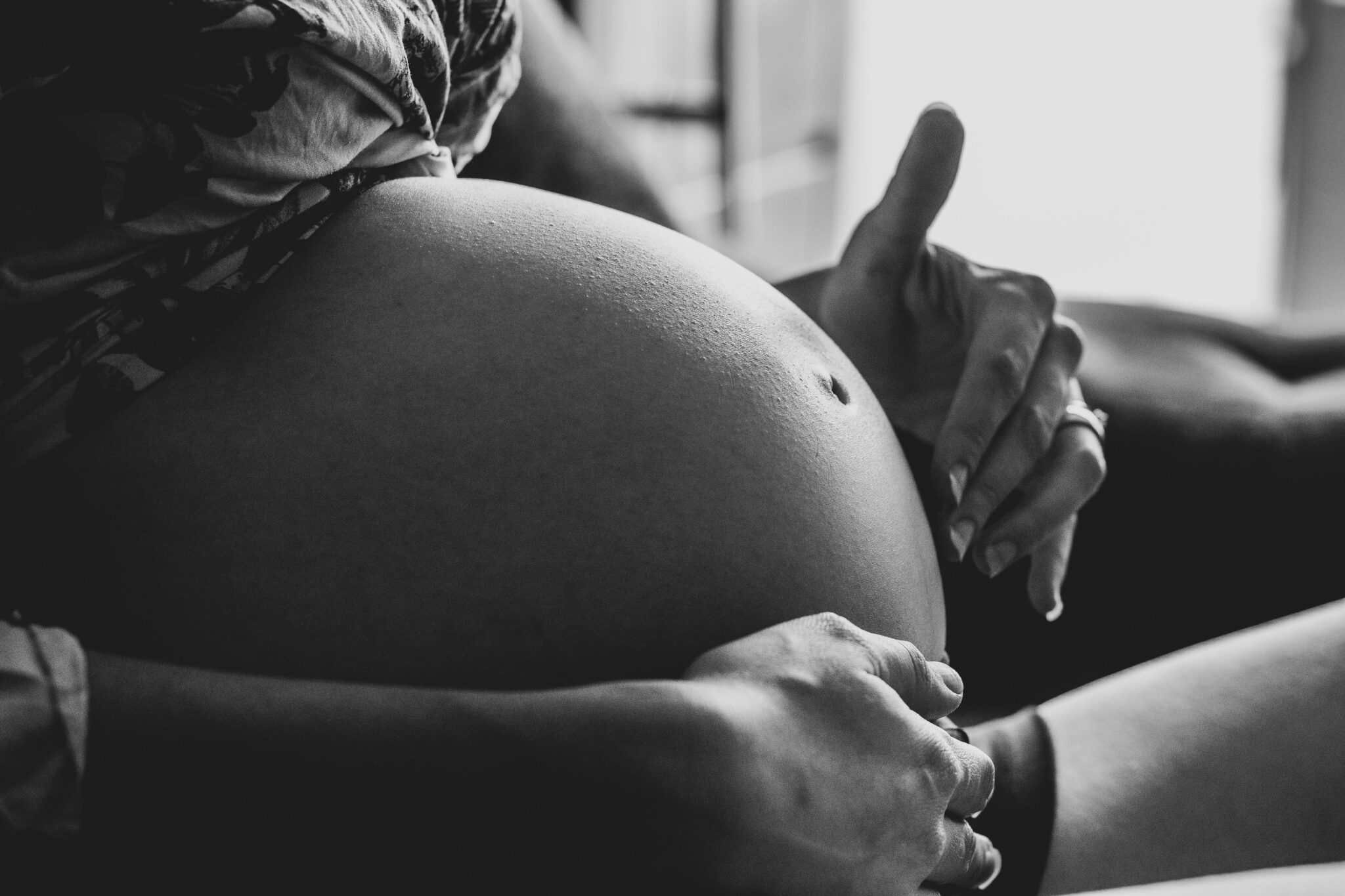 Zwangere vrouw die haar baby in haar buik voelt bewegen