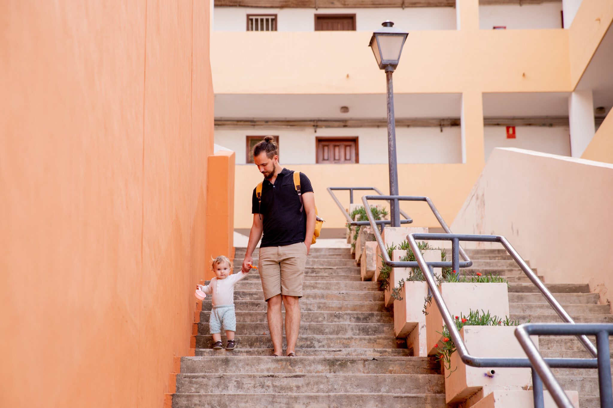 Vader die zijn dreumes helpt bij het leren traplopen op vakantie
