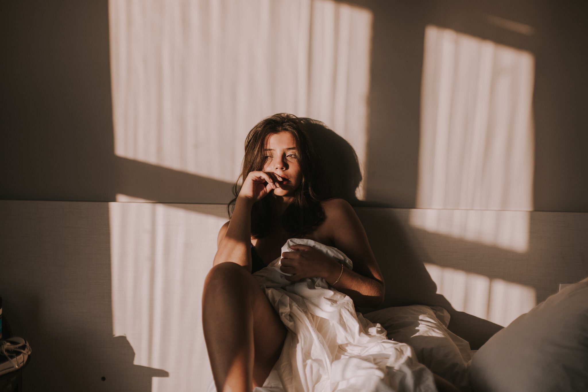 Vrouw die verdrietig in bed zit omdat ze slechte seks heeft door de stress