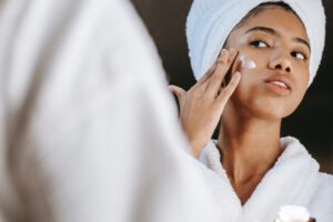 Vrouw die gefermenteerde skincare op haar gezicht smeert