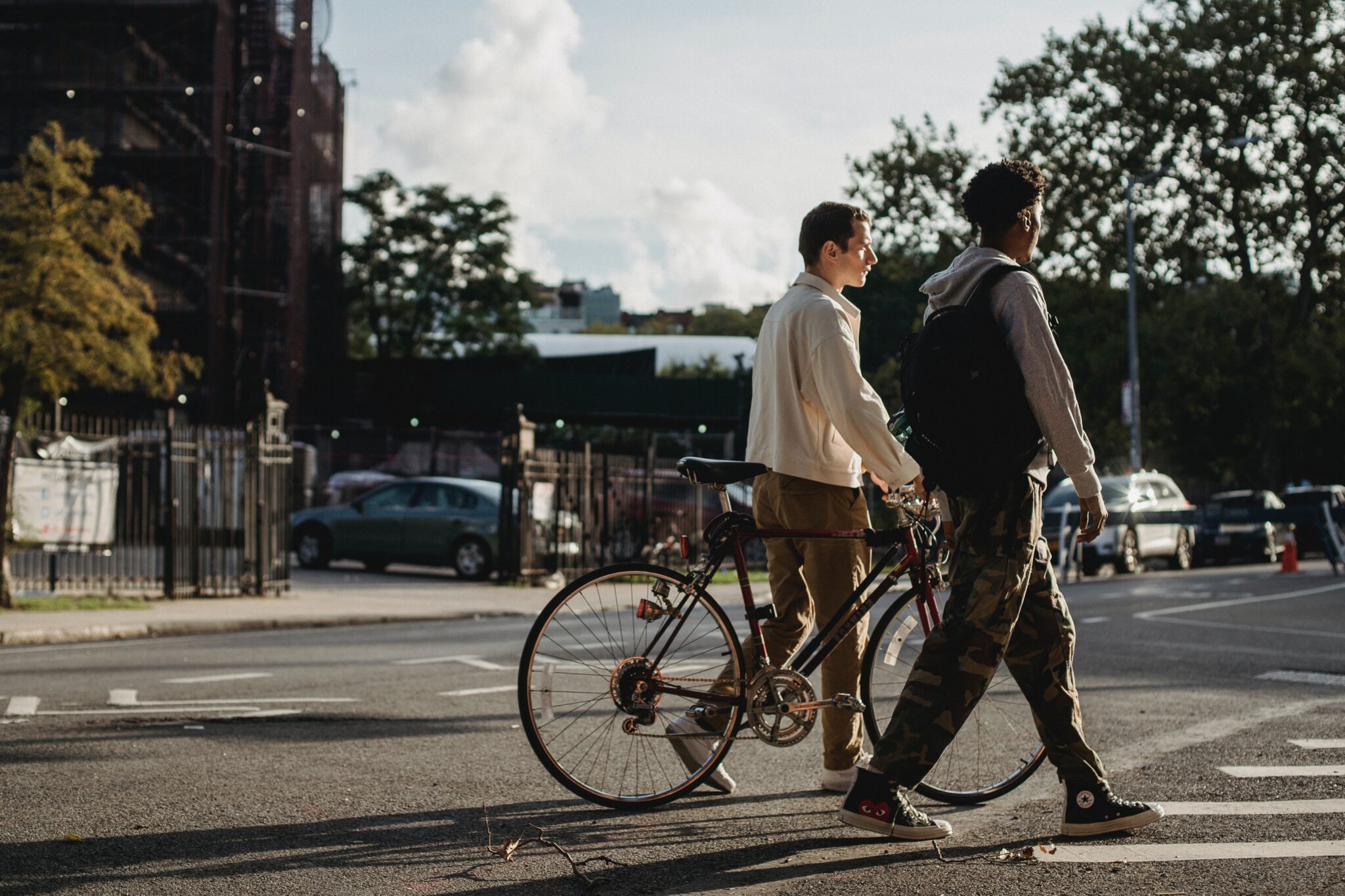 Twee tieners die over straat lopen met een fiets