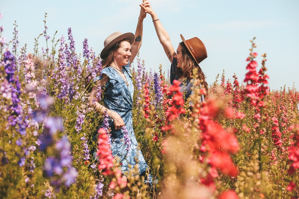 zus / twee vrouwen dansen in bloemenveld