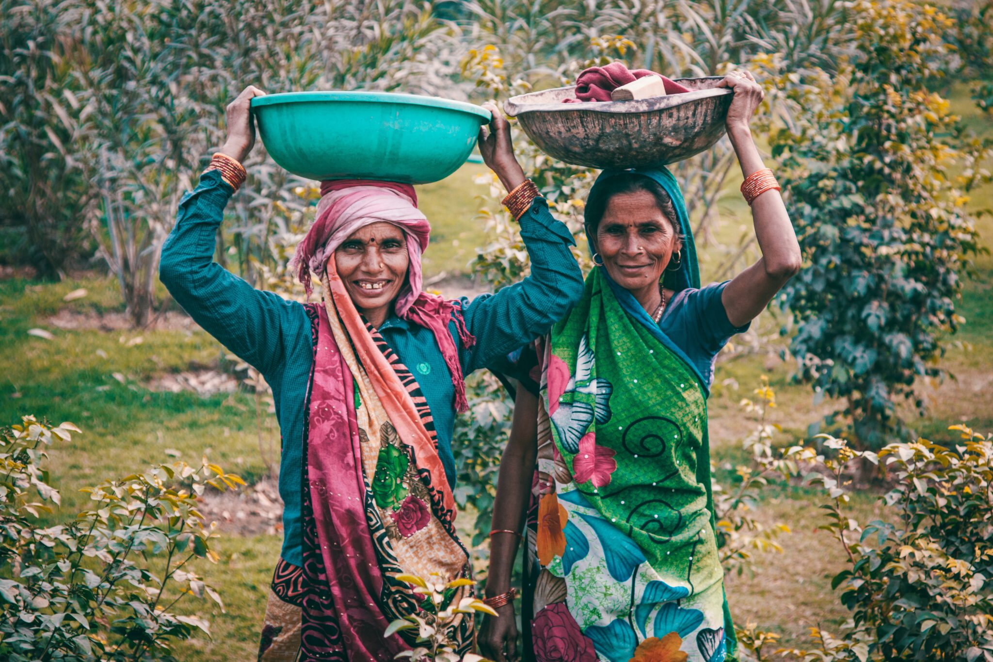 Twee vrouwen dragen manden met eten op het hoofd. Gezonde gewoonten van over heel de werelfd