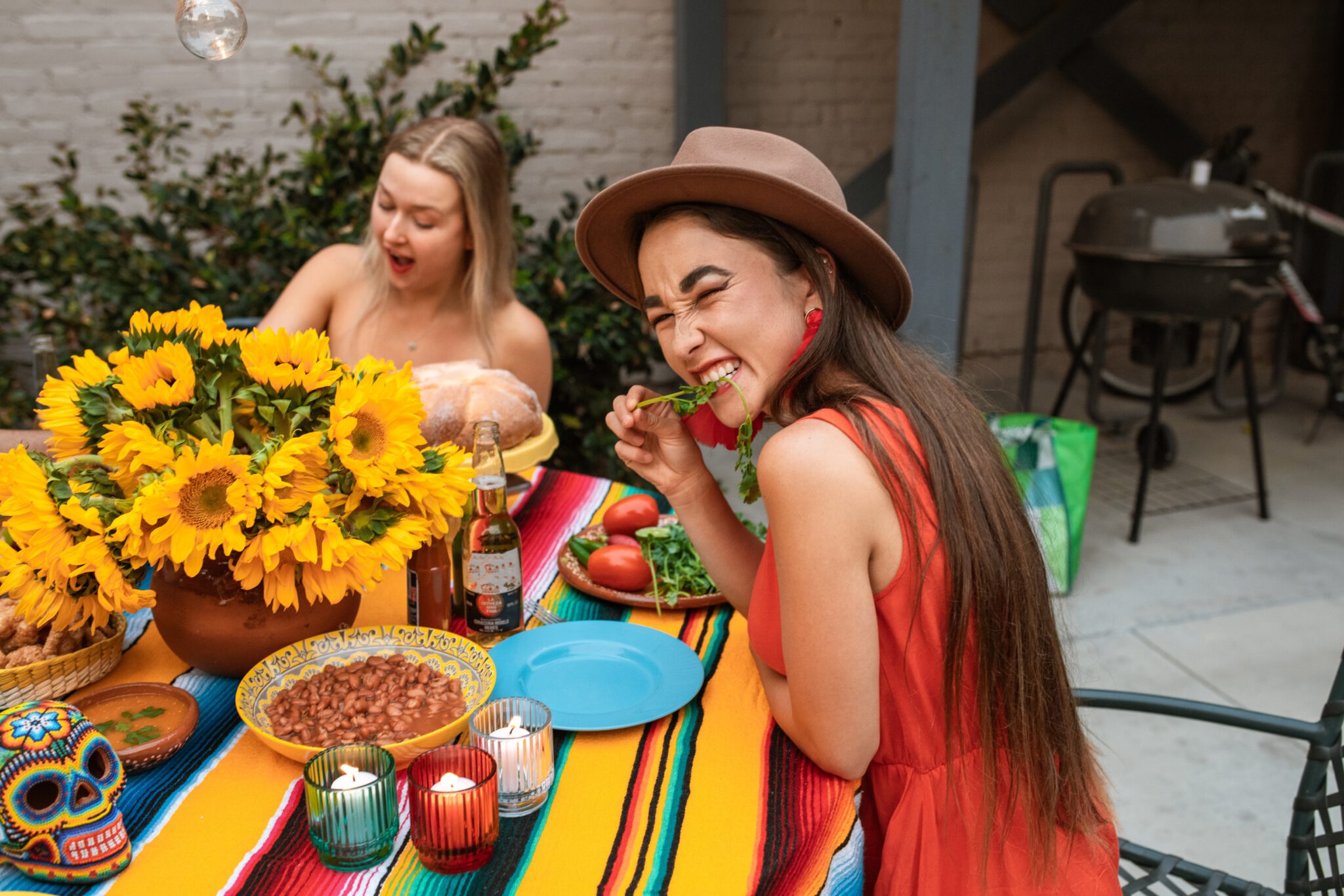 twee vrouwen in kleurrijke jurken eten een gezonde vegan maaltijd