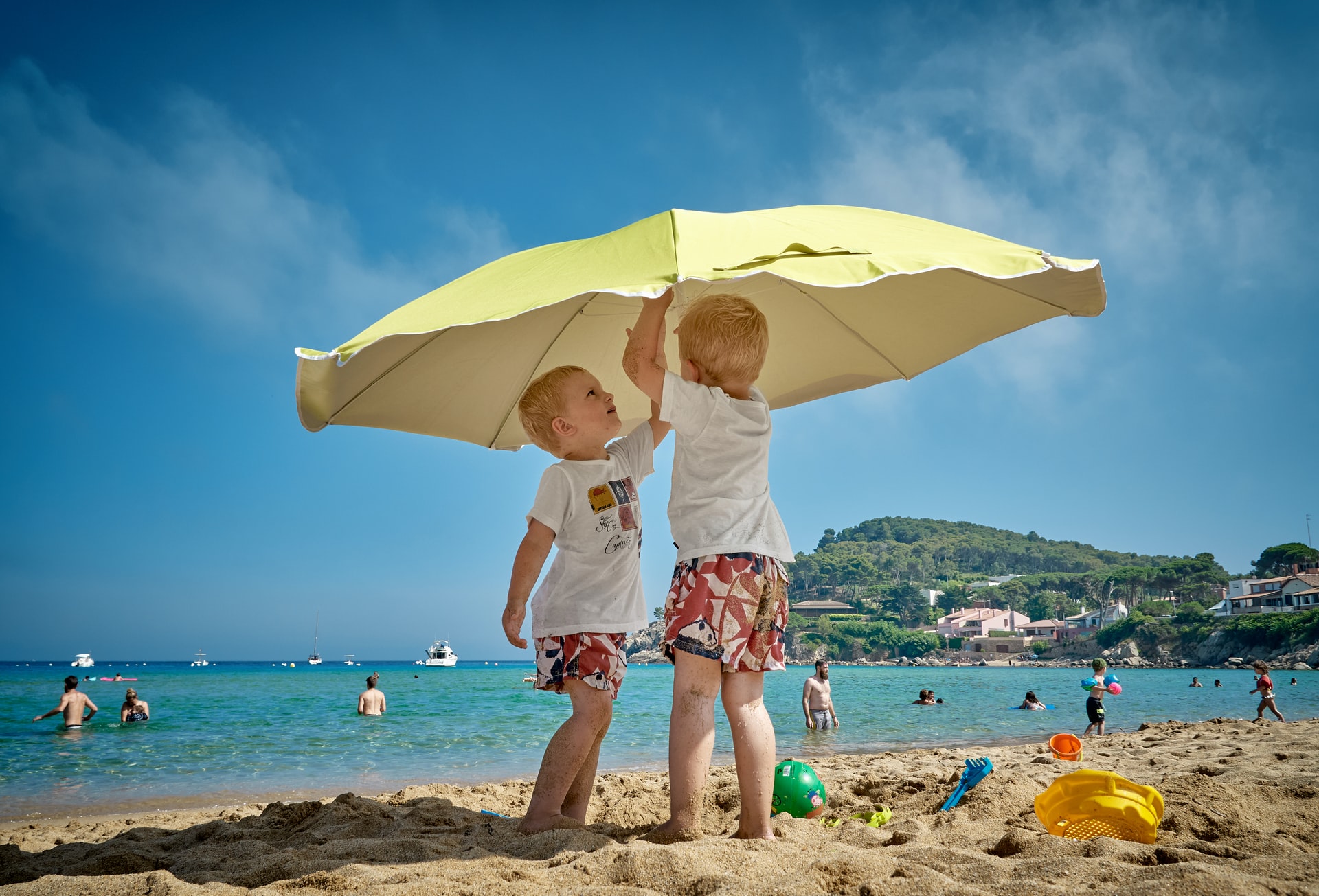 kinderen onder een paraplu in de zon