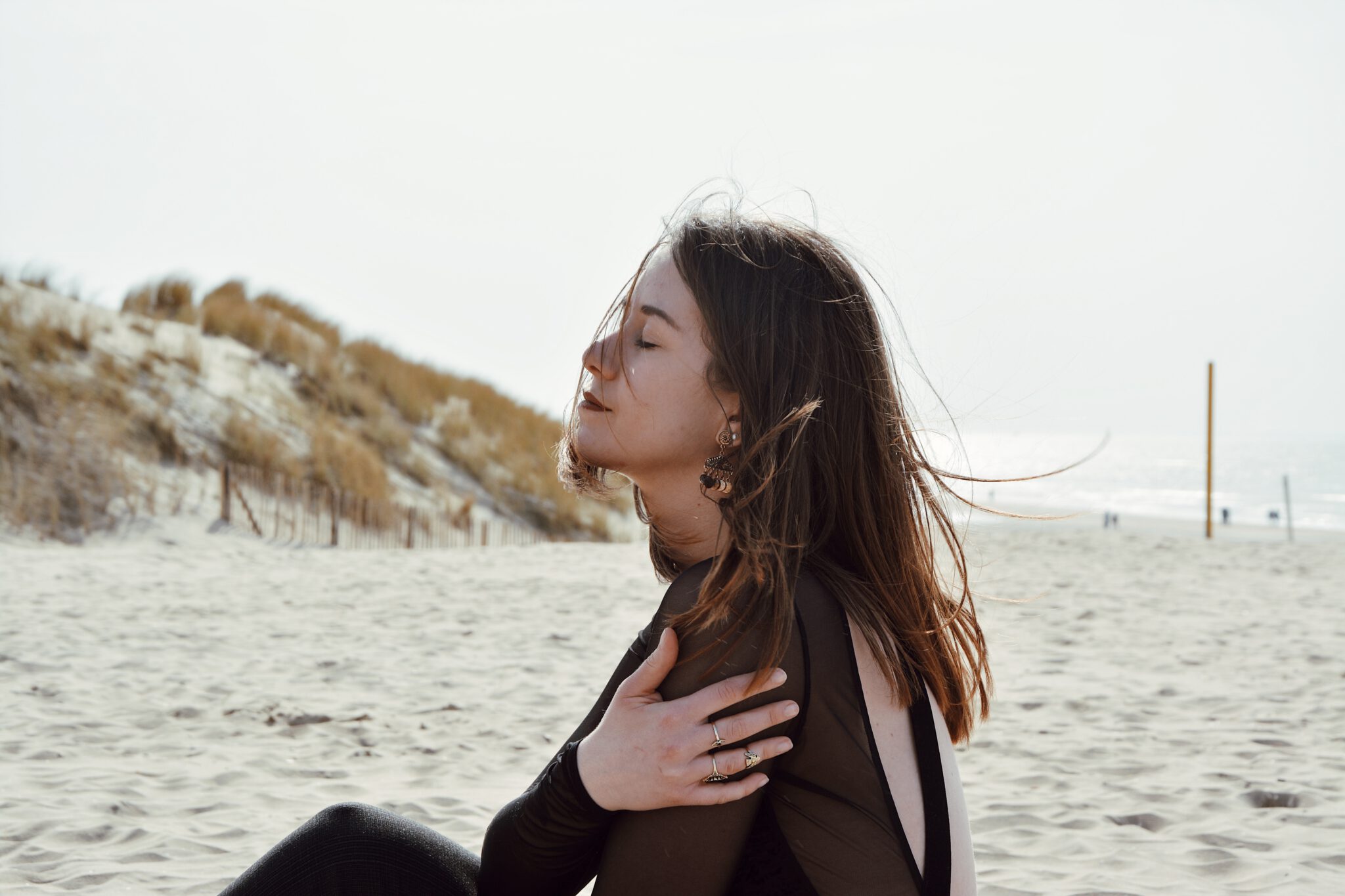 Vrouw op strand met ogen dicht , waarbij mythen rondom gezondheid wordt ontkracht
