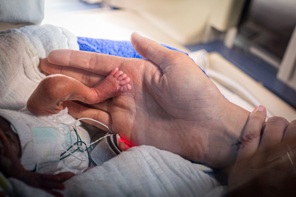 handen aan de couveuse baby ace